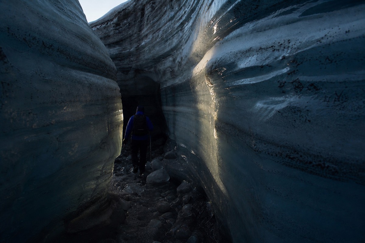 Banded blue glacier ice inside a Svalbard ice cave lit by a head torch