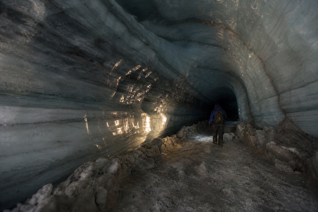 Blue banded glacier ice inside a Svalbard ice cave, lit by a head torch