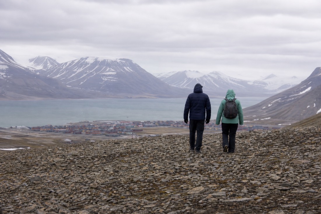 Walkers on the flat top of Platafjellet looking down over Longyearbyen and Adventfjorden